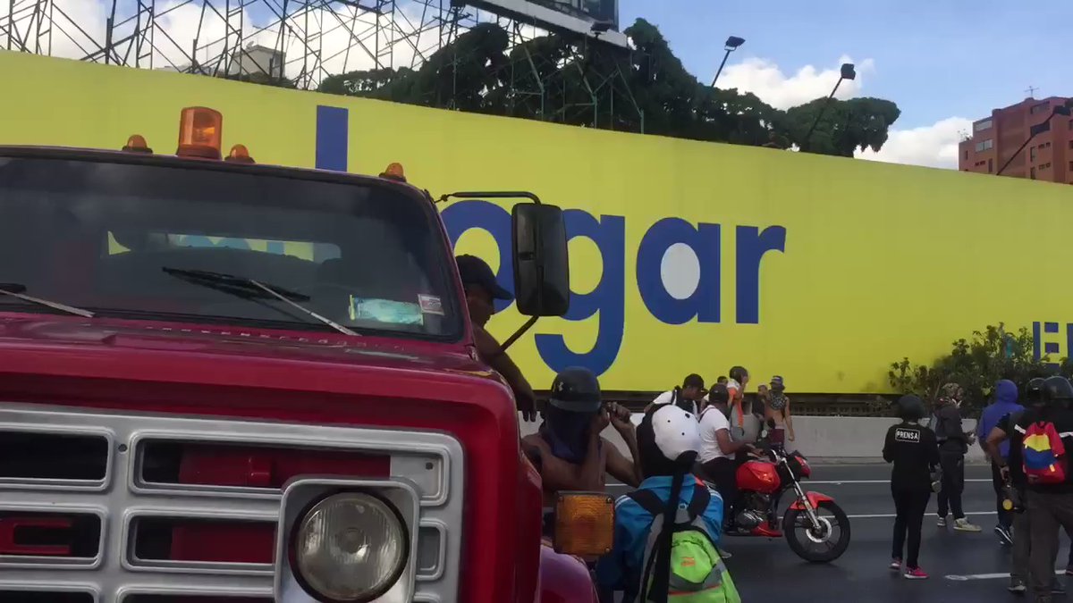 Demonstrators try to use 2 trucks to keep the passage closed on the Francisco Fajardo highway near Las Mercedes. In the end they let them go