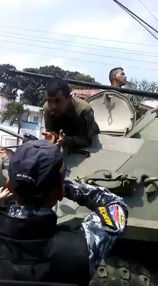 Bolivarian National Guard and the National police arguing in the city of Ureña, Venezuela next to the  Colombian border. While local residents screaming let the foreign aid pass while blocking the streets with bikes.   