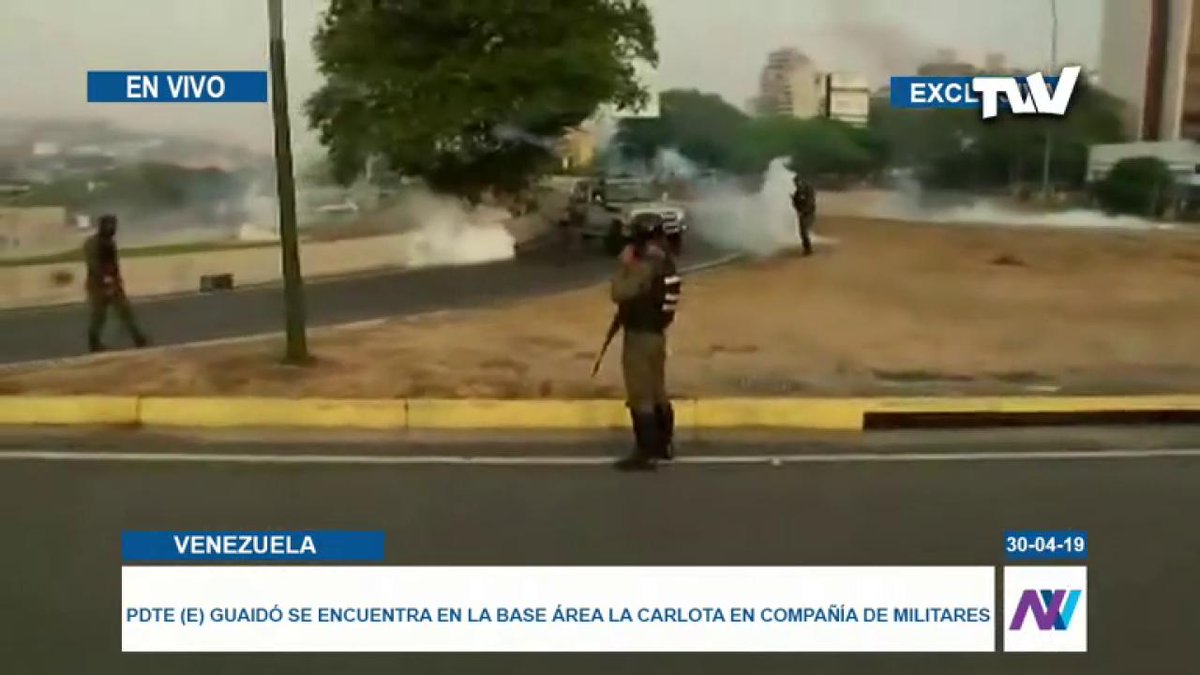 Military officials who support Juan Guaidó, use blue ribbon on their arms and return tear gas bombs thrown at the  Altamira Interchange from La Carlota Air Base.