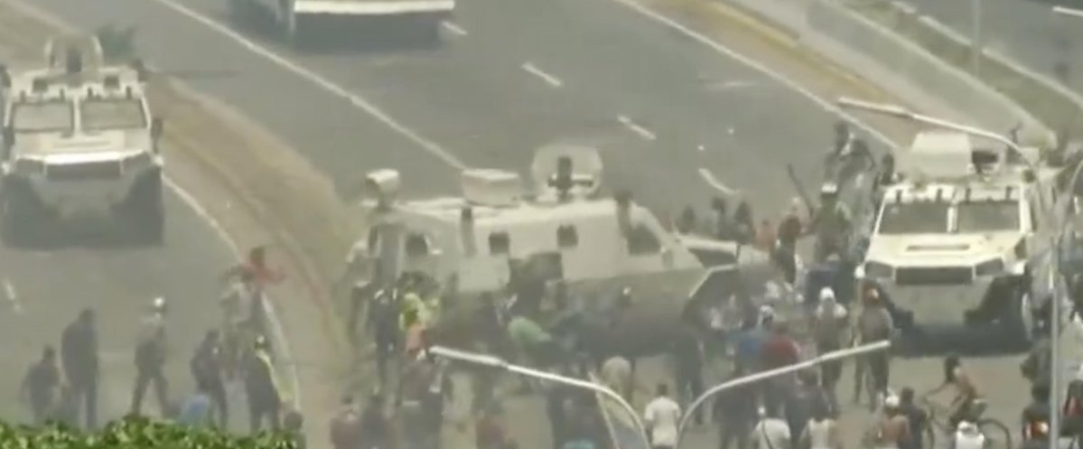 Armoured vehicles of the Bolivarian Guard run over protesters near La Carlota base