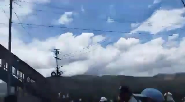 Des officiers de la Garde nationale (GNB) regardent les manifestants allumer des pneus en feu sur l'autoroute Caracas - La Guaira