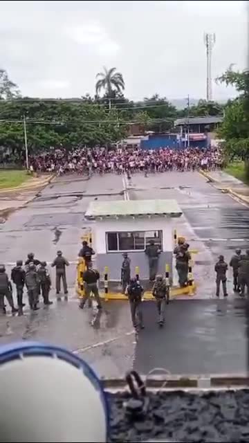 Große Menschenmenge von Demonstranten steht vor einem venezolanischen Luftwaffenstützpunkt dem Militär gegenüber