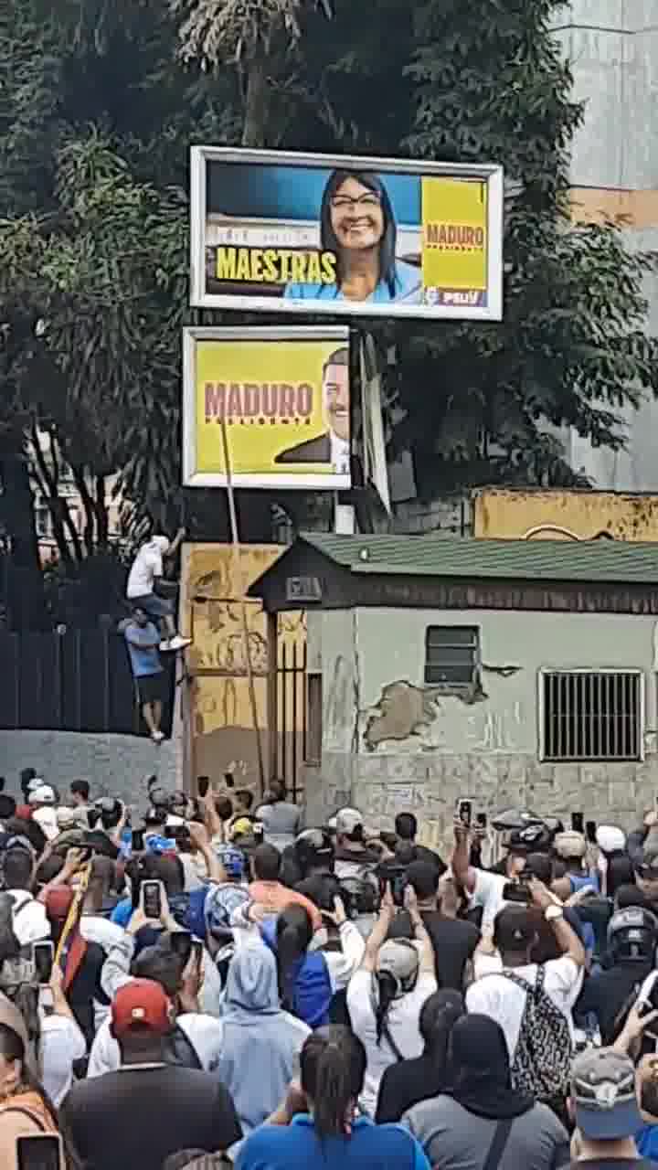 Des manifestants tentent de renverser un panneau de propagande de Maduro à La California