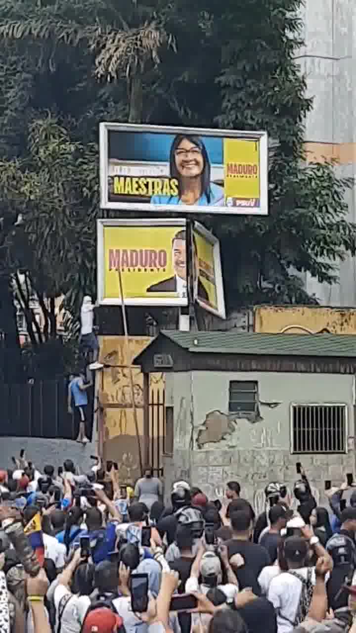 Des manifestants tentent de renverser un panneau de propagande de Maduro à La California