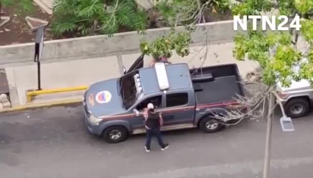 Police agents take journalist Carmela Longo and her son from their home in Caracas