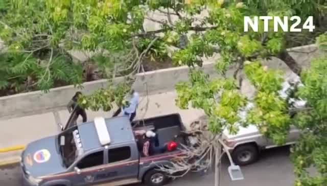 Police agents take journalist Carmela Longo and her son from their home in Caracas