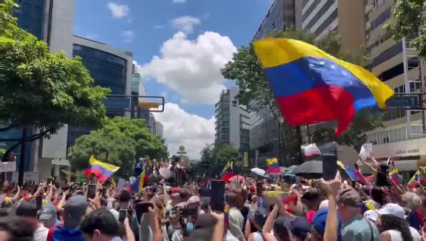 Setki osób wita Marię Corinę Machado na alei Francisco de Miranda w Caracas w ramach protestu zorganizowanego miesiąc po wyborach prezydenckich z 28 czerwca