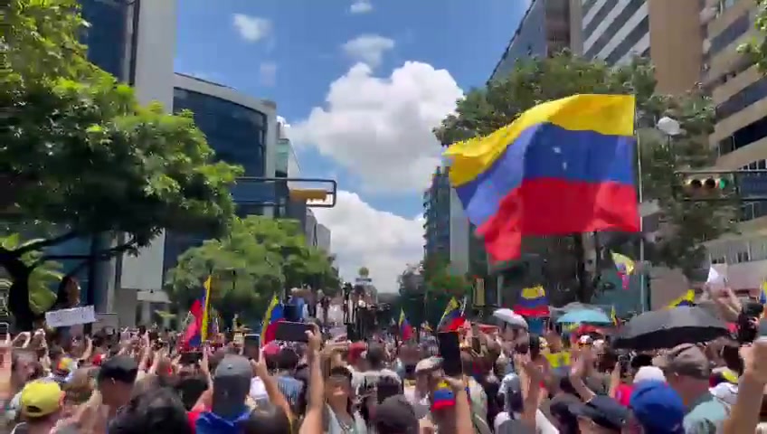 Setki osób wita Marię Corinę Machado na alei Francisco de Miranda w Caracas w ramach protestu zorganizowanego miesiąc po wyborach prezydenckich z 28 czerwca